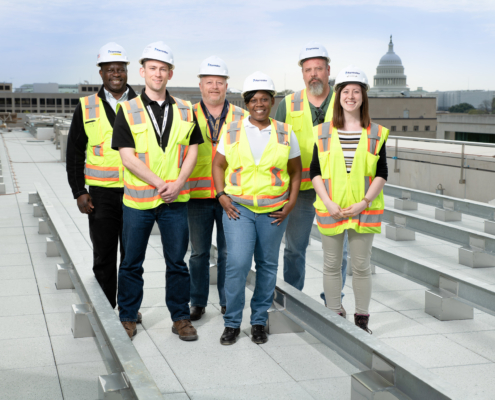 Forrester Construction DC Courts C Street Team posing on roof of project in front of the Washington DC Capitol Building