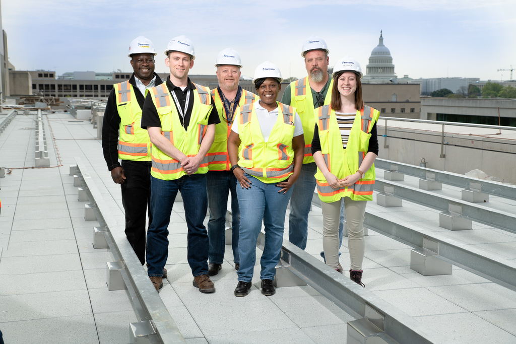 Forrester Construction DC Courts C Street Team posing on roof of project in front of the Washington DC Capitol Building